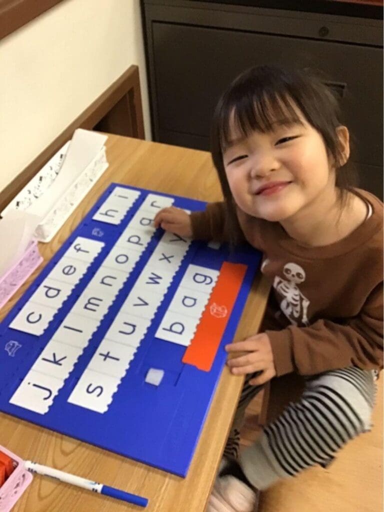 A student smiles as she works on a reading project.